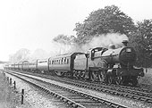 LMS 4-4-0 'Compound' 4P No 1062 storms past whilst at the head of a ten coach holiday express  passenger service