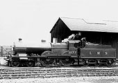 LMS 4-4-0 "Compound" No 1077 stands light engine with the fireman working on the coal in the tender