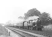 LMS 4-4-0 'Compound' 4P No 1062 storms past whilst at the head of a ten coach holiday express  passenger service during the summer of 1936