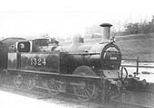 Ex-MR 1P 0-4-4T No 1324 wearing shed plate No 3 stands at the head of a local					passenger train in the station