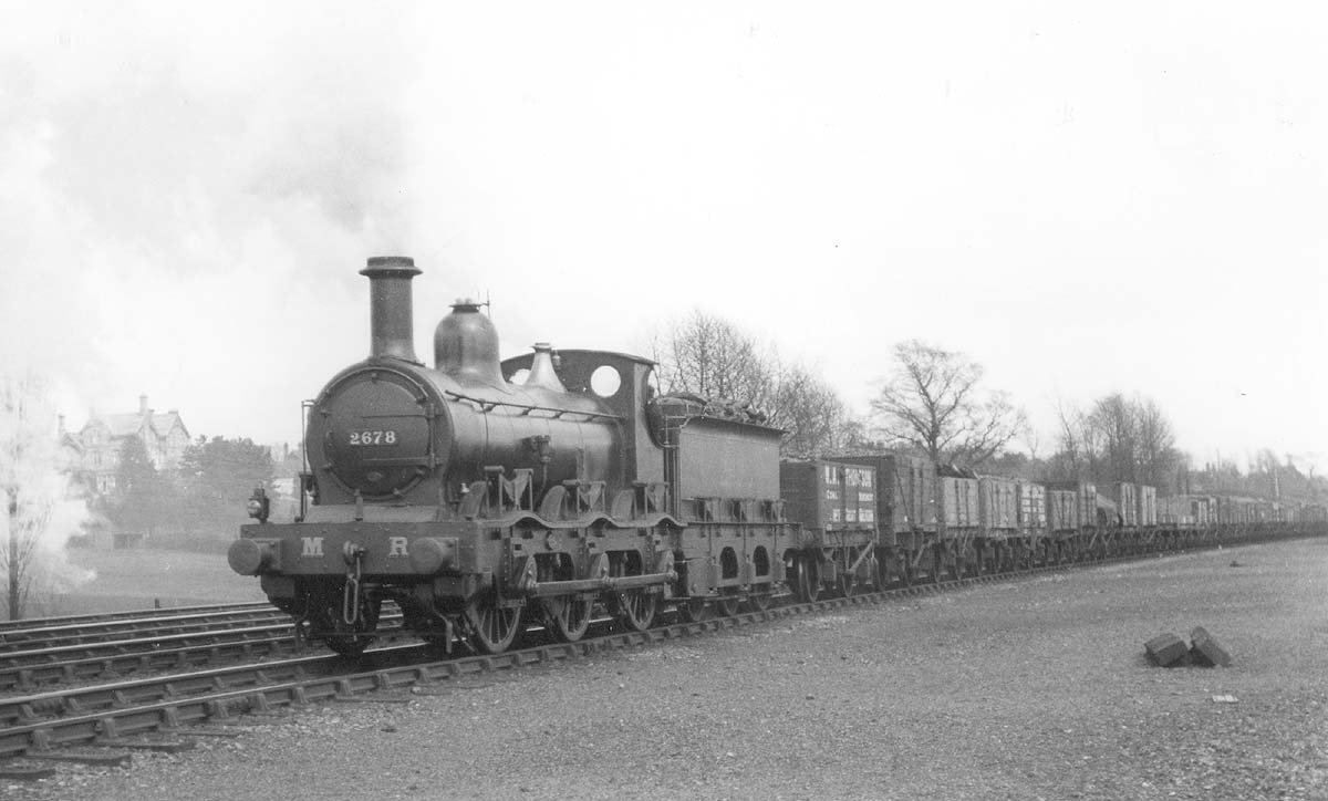 MR Kirtley outside-framed 0-6-0 No 2678 at the head of a long train of assorted open wagons passing the carriage sidings