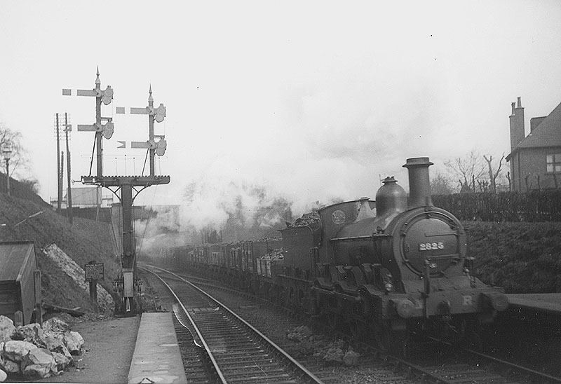 MR 0-6-0 No 2825 is seen at the head of a long down train of coal wagons as it enters Kings Norton station