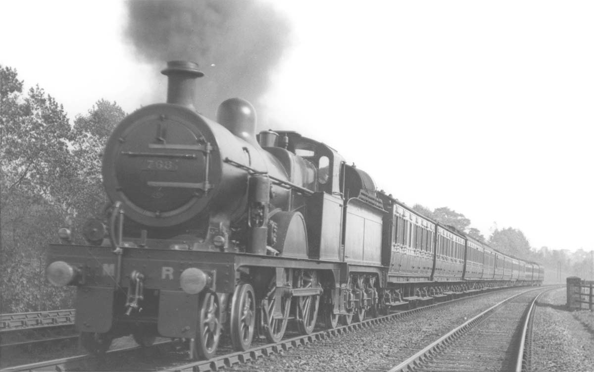 MR 4-4-0 3P No 768, converted for oil firing, is seen at the head of a down express train south of Kings Norton