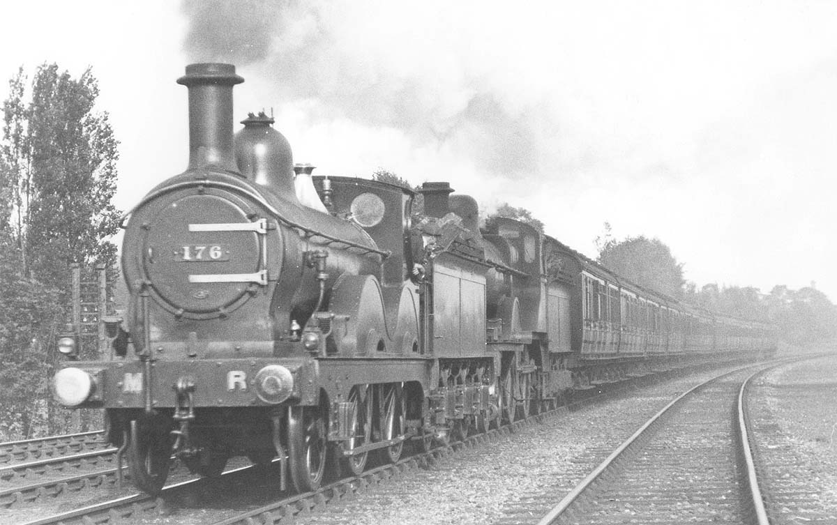 MR Kirtley 2-4-0 No 176 is working hard as it doubleheads MR 4-4-0 No 518 on a down express passing the carriage sidings