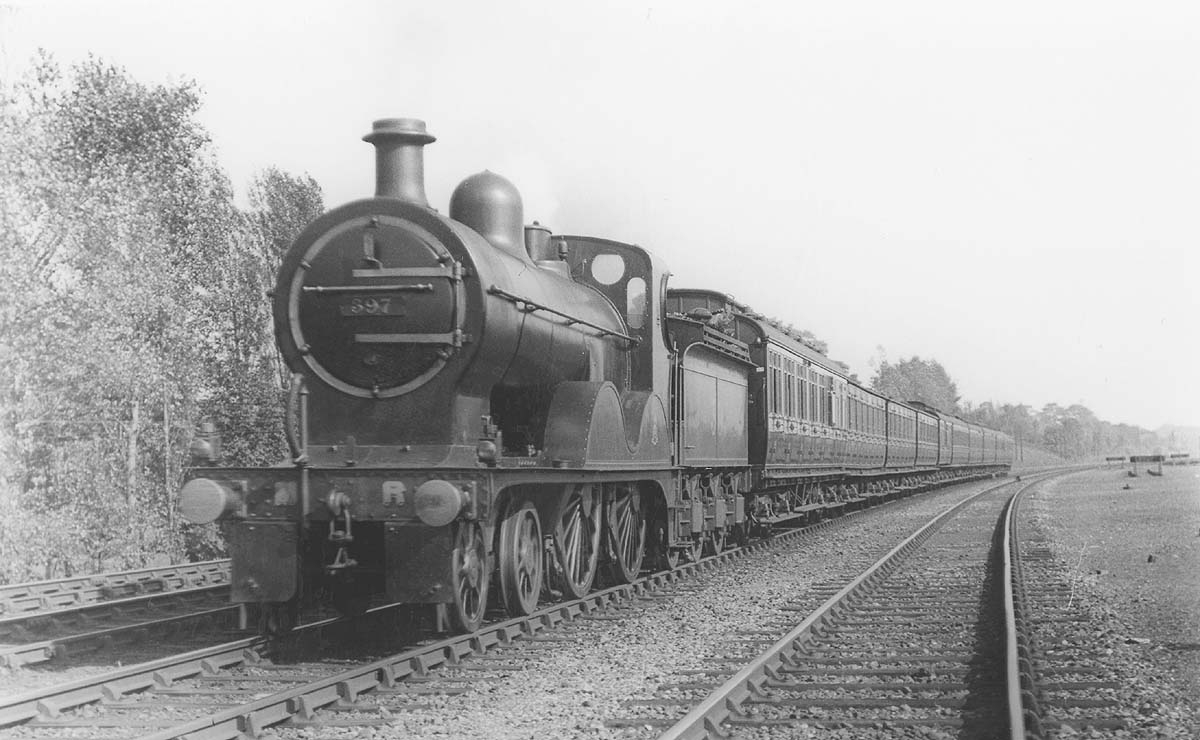 MR 4-4-0 No 397 is seen at the head of a down express passenger train made up of mixed coaching stock