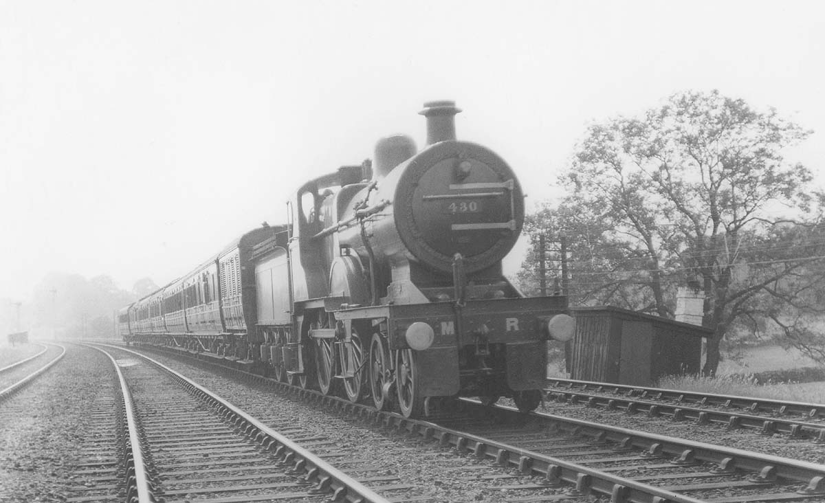 MR 4-4-0 No 430 rushes past a Permanent Way gang's line side hut whilst at the head of an up express