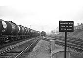 A down train of Esso Class B 4-wheel tank wagons passes Kings Norton goods yard as ex-MR 0-4-0 No 41535 and an unidentified ex-LMS 4-6-0 Black 5 locomotive approach the camera
