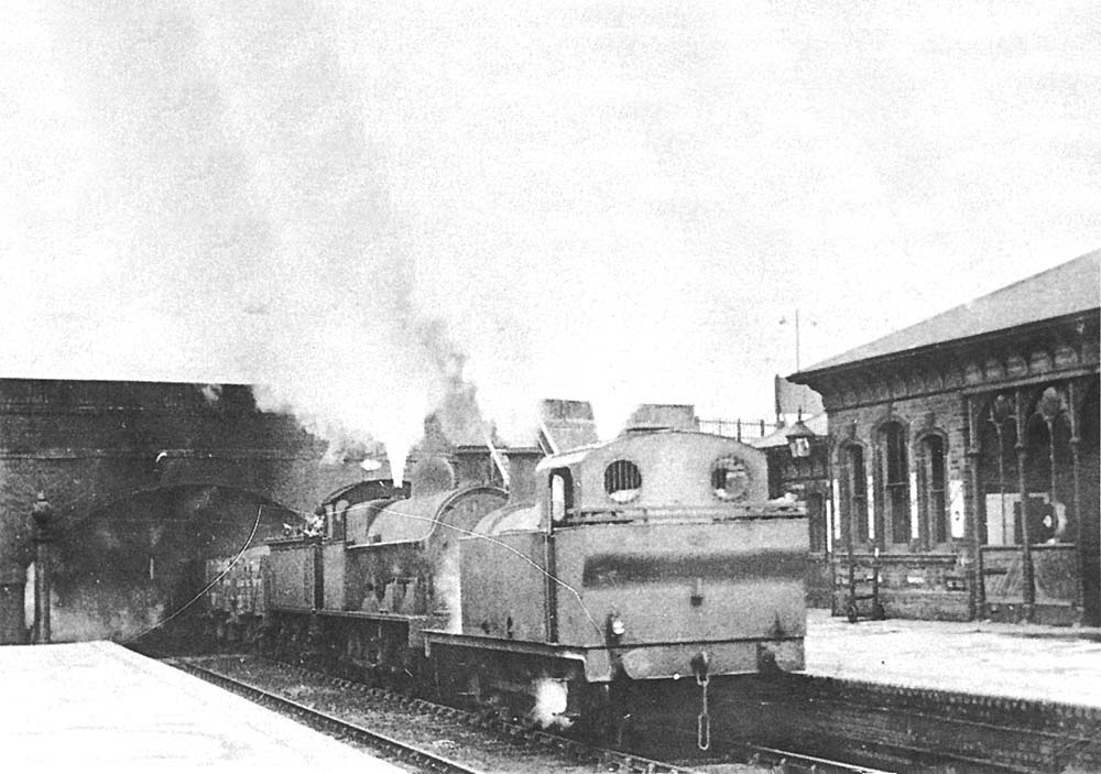 A 1937 photograph showing an unidentified ex-LMS 3F 0-6-0 locomotive piloting an unknown ex-LNWR 0-8-0 locomotive on a freight through Abbey Street station