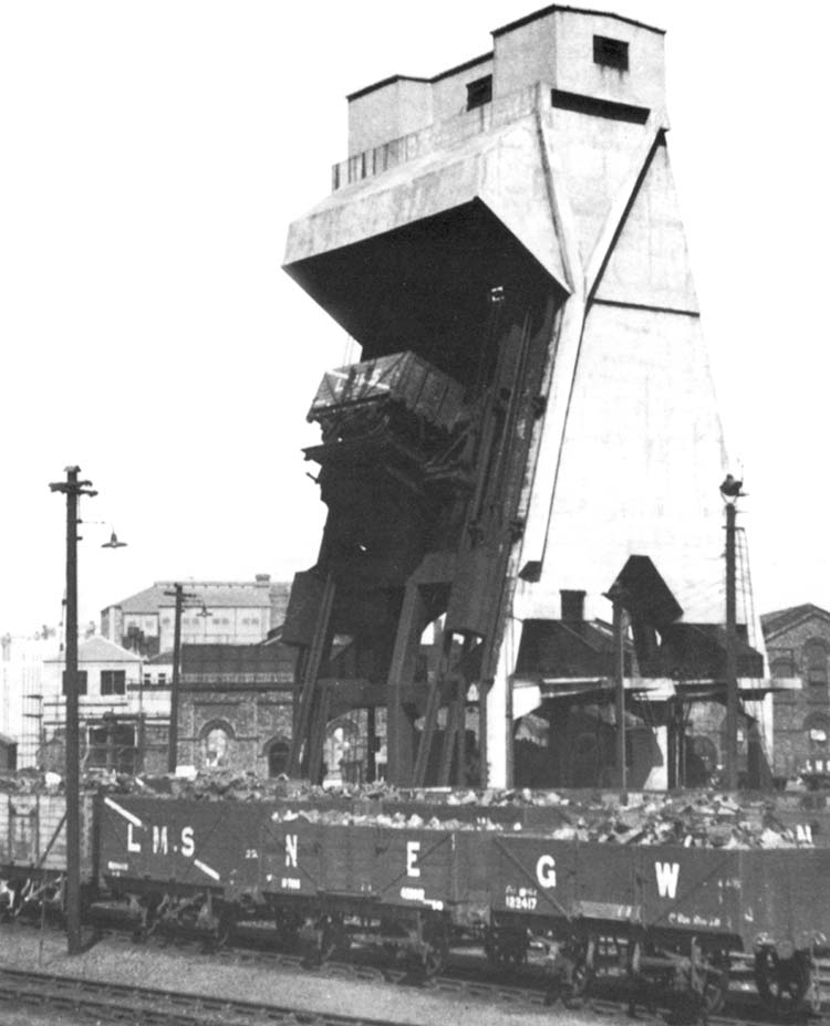 View of Saltley shed's mechanical coaling plant showing both a range of different railway company wagons and a wagon being hoisted to the top for tipping