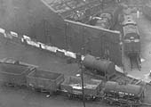 Close up of the corner of Saltley shed's war-damaged No 3 roundhouse and the open and tank wagons stored on the siding adjacent to an oil tank