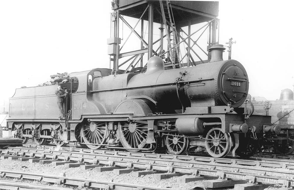 Ex-MR 4P 4-4-0 Compound No 1014 is seen standing next to the Ash Plant as the crew clean the fire as evidenced by the fire irons leaning against the footplate
