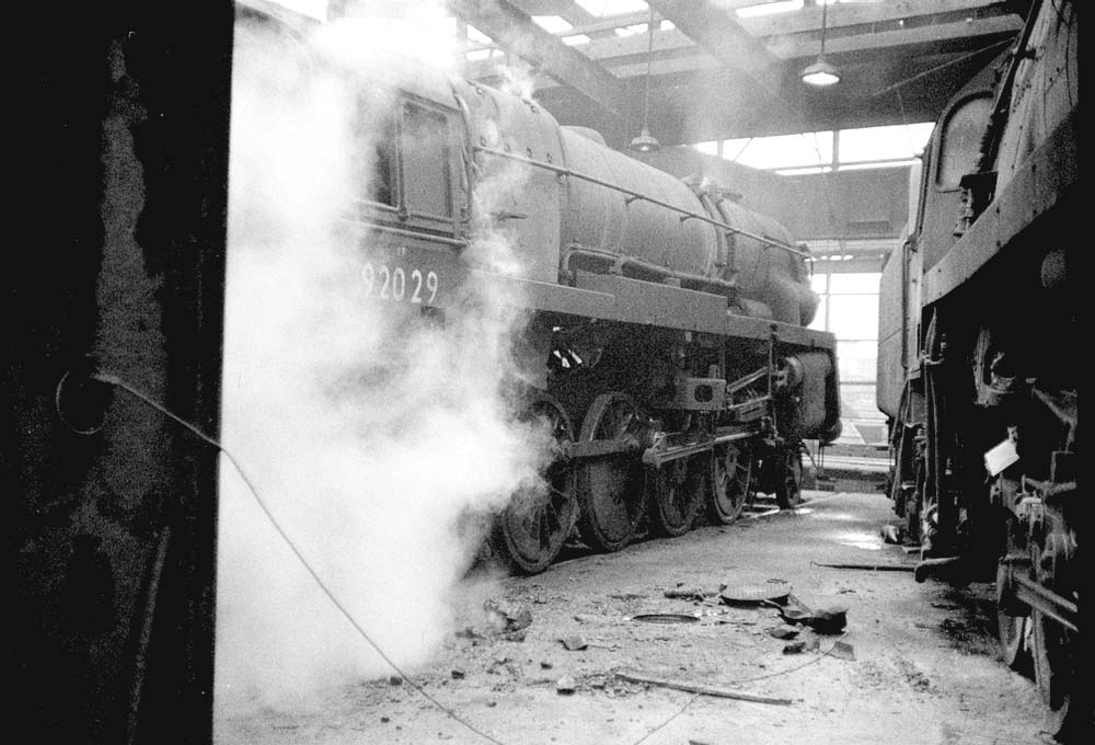British Railways Standard Class Crosti-boilered 9F 2-10-0 No 92029 is wreathed in steam as it prepares to depart the roundhouse
