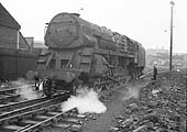 British Railways Standard Class Crosti-boilered 9F 2-10-0 No 92029 runs forward to clear the points outside the shed