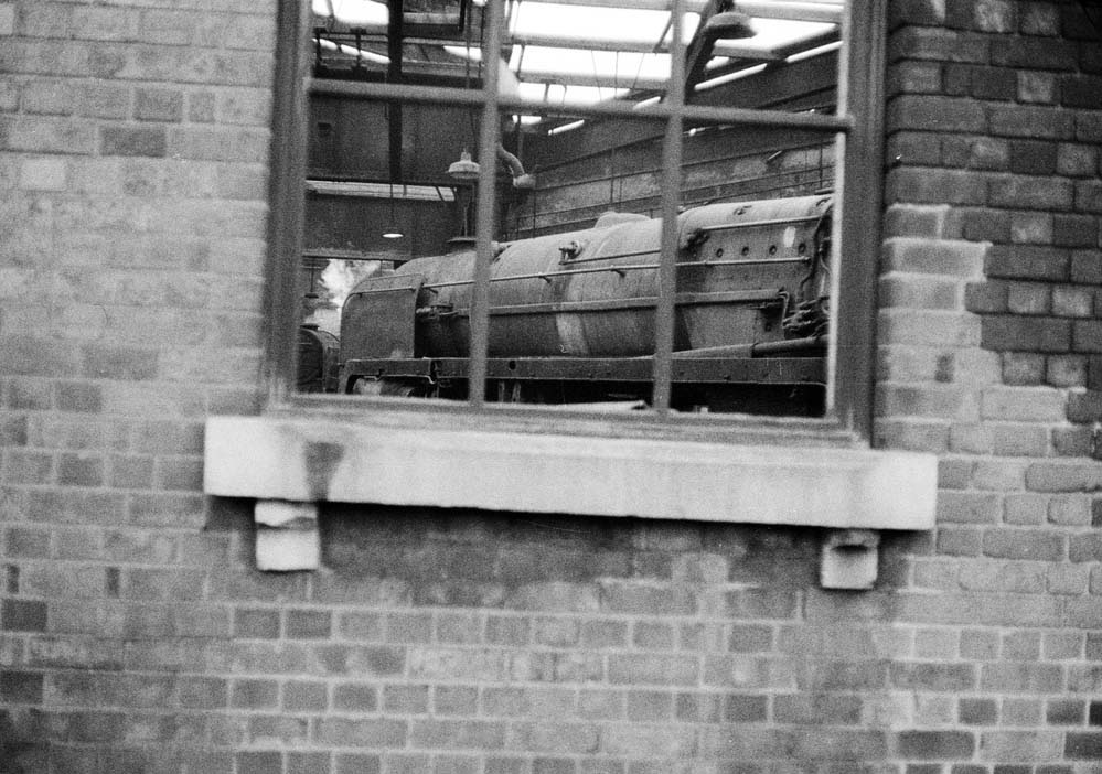 British Railways Standard Class 9F locomotives are seen through the non-glazed windows of Saltley shed's No 3 roofless roundhouse