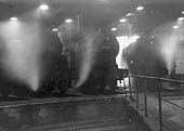 Ex-LMS 4F 0-6-0 No 44180 stands inside Saltley No 2 Shed as an unidentified BR Standard 4-6-0 enters the shed