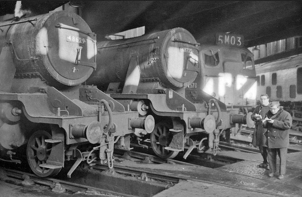 Ex-LMS 8F 2-8-0 No 48629 and classmate No 48725 stand inside the shed with BRCW Type 2 diesel locomotive D7570 on 28th November 1965