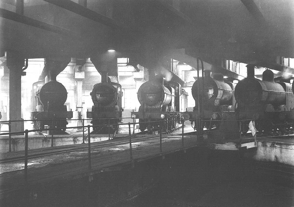 An inside view of Saltley shed showing four ex-MR 3F 0-6-0s and an ex-MR 4F 0-6-0 standing around Saltley shed's turntable