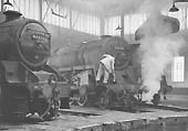 BR Standard 9F 2-10-0 No 92138 and BR built 5MT 4-6-0 No 44691 stand around one of the roundhouses