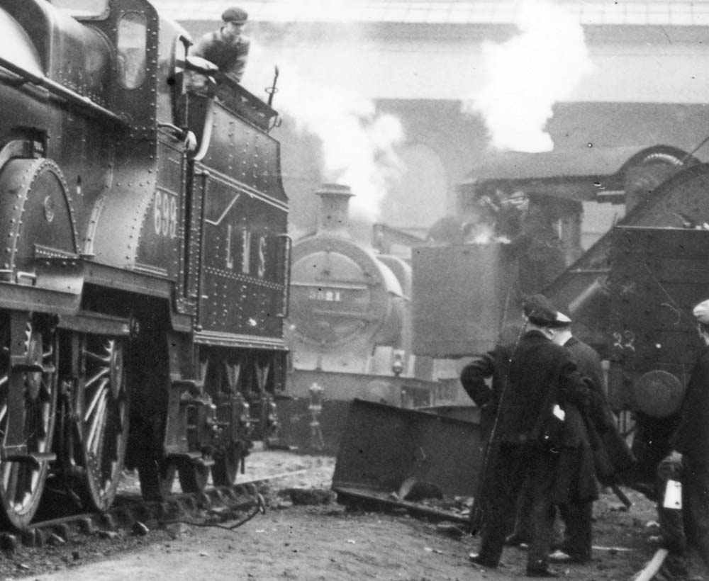 Close up showing railwaymen looking on as Saltley shed's breakdown crane is being employed to the front of the No 3 roundhouse