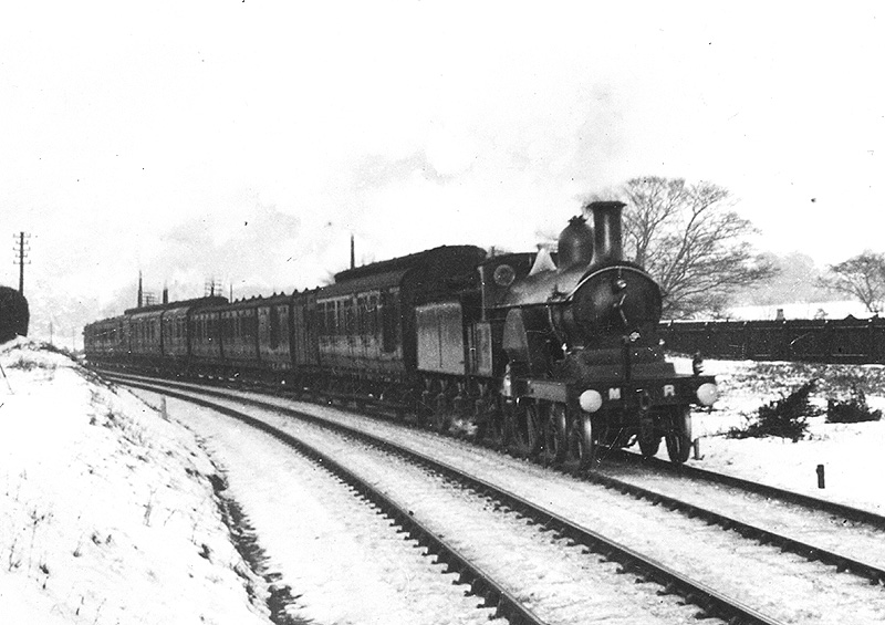 An unidentified MR Single 4-2-2 at the head of a train comprised of a very mixed bag of rolling stock