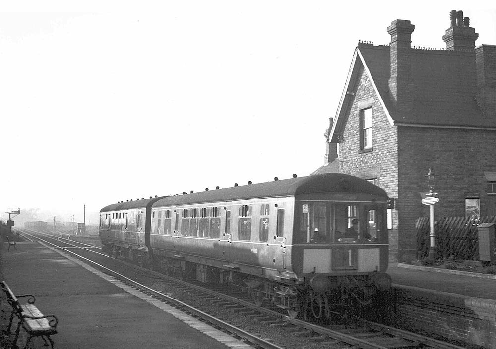 A two-car Gloucester RCW DMU is seen arriving on the diverted 1:10pm New Street to Rugby local train on 8th December 1963