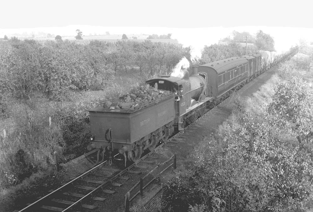 Ex-MR 3F 0-6-0 No 43520 is seen near Bidford on a goods train made up of an ex-LMS 50' brake, fitted vans and sheeted open wagons