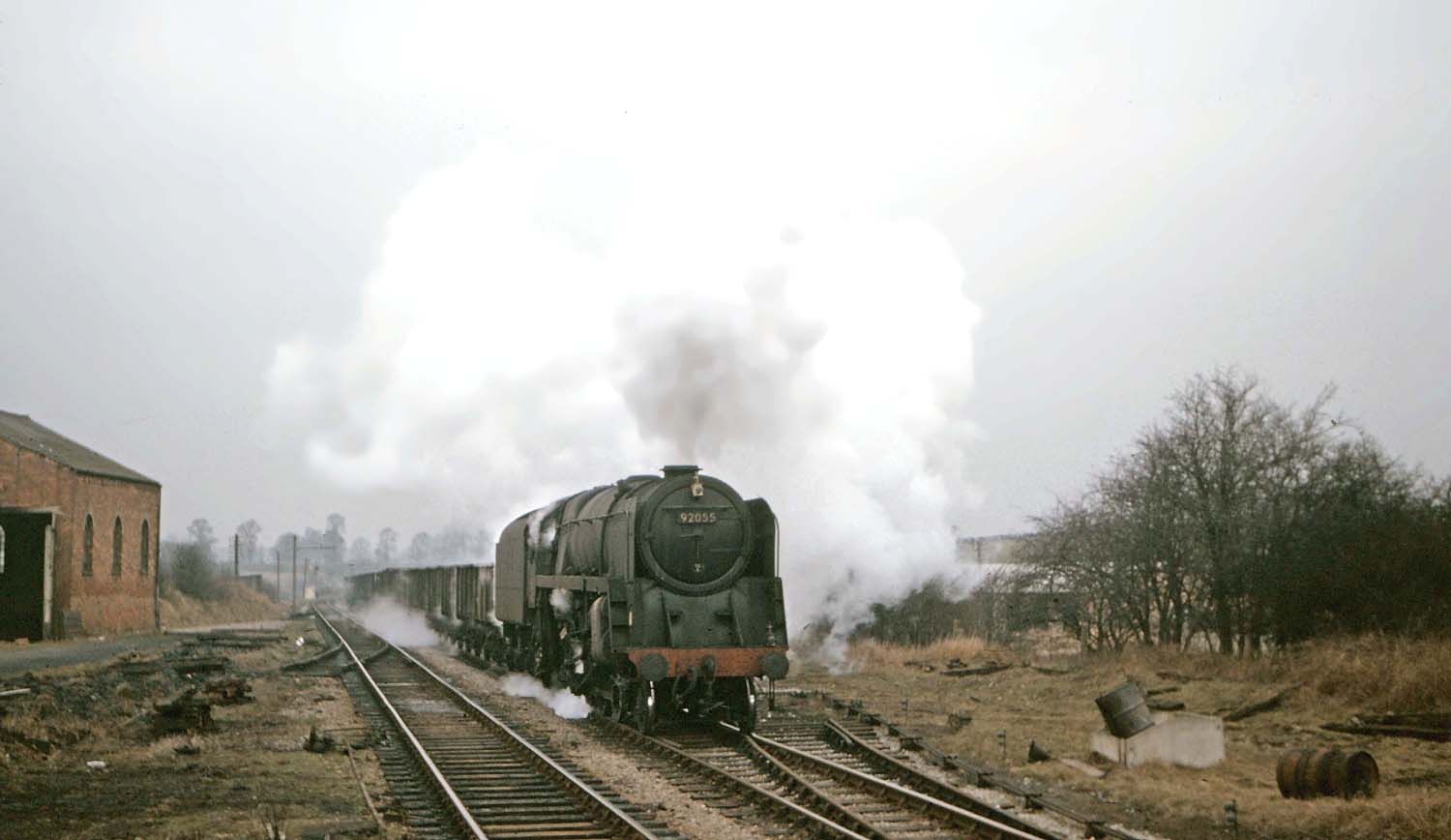 British Railways Standard Class 9F 2-10-0 No 92055 proceeds through the remains of Kineton station during the early 1960s