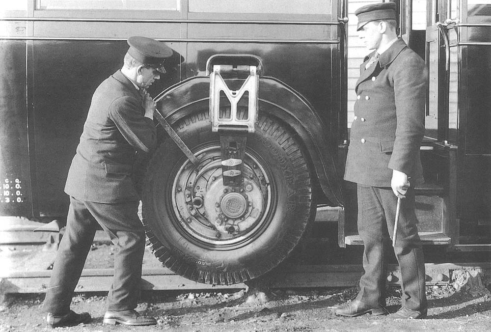 The driver uses a lever to raise the road wheel on the eccentric, the man on the right holds one of the holding pins