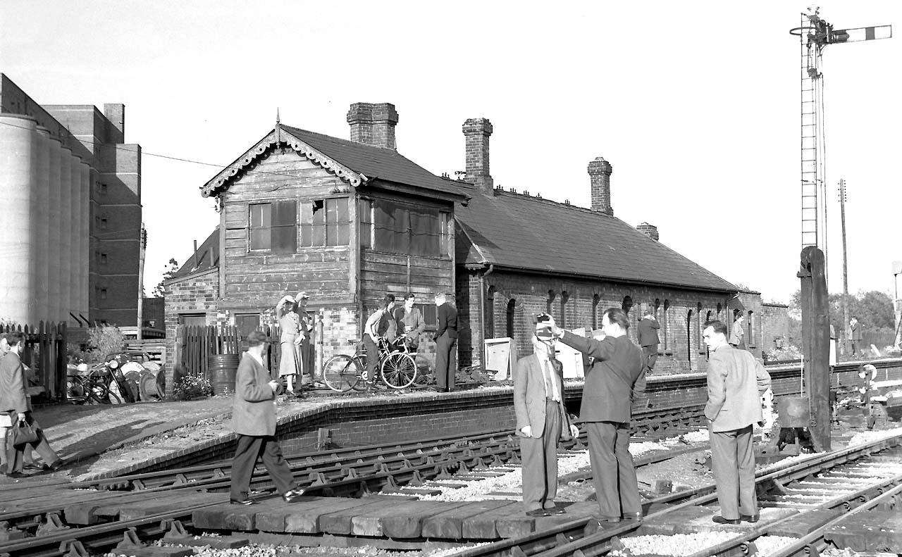 A visiting party of enthusiasts look around the near derelict E&WJR signal box and station building on 14th May 1960