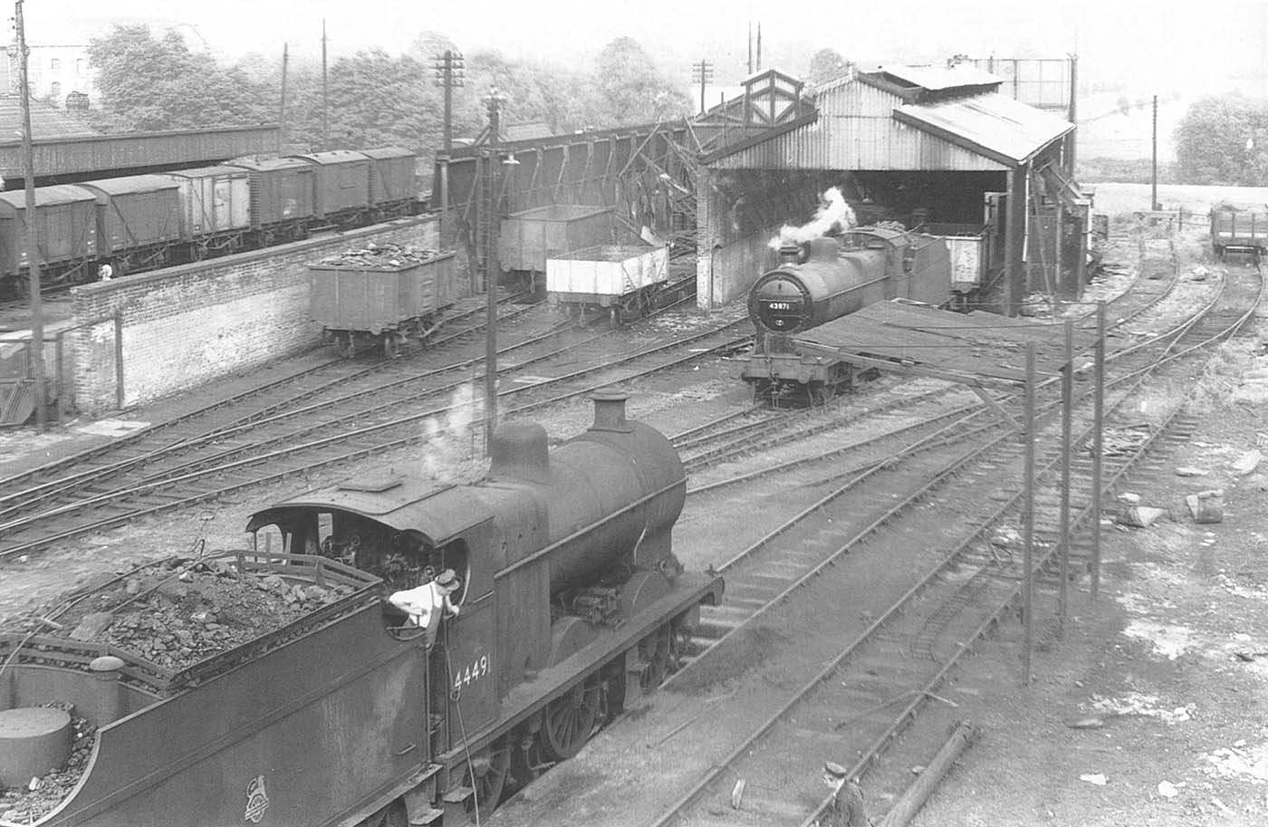 Two ex-LMS 4F 0-6-0 locomotives, No 44491 and No 43971, work within the confines of the rebuilt shed as its being demolished on 2nd July 1957