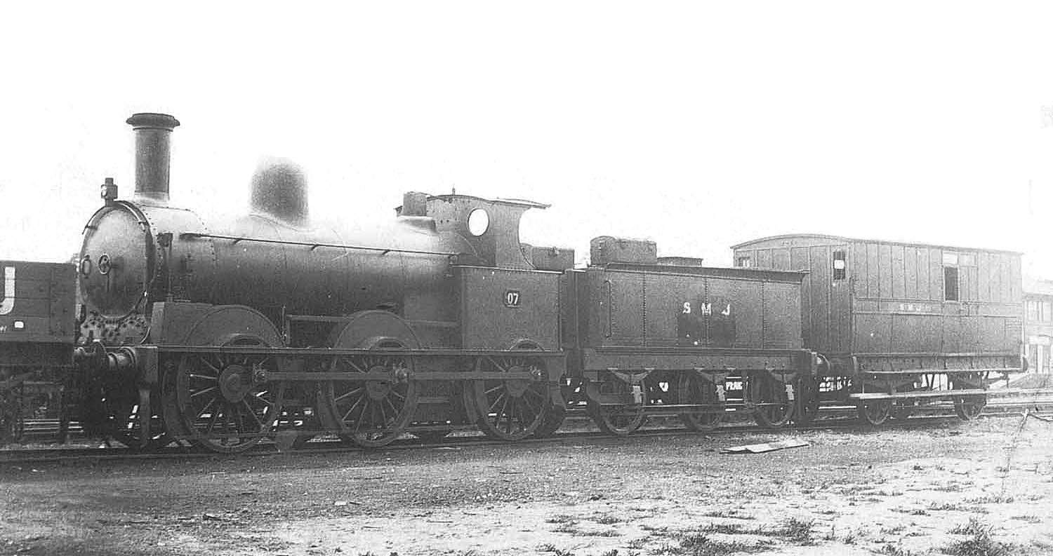 E&WJR 0-6-0 No 7, a former LNWR 'DX Goods' locomotive now in its SMJ post 1920 guise, with a tool van in tow outside the shed