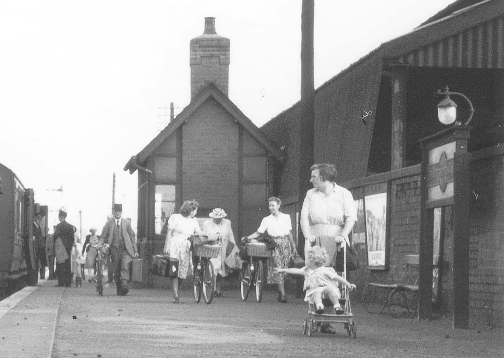 Close up showing passengers  leaving the platform with many people  wheeling bicycles from the train