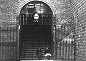 Two girls pose for SWA Newton's camera seated at the bottom of the staircase leading up to the station
