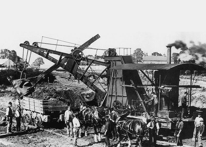 A steam navvy is seen loading spoil on to a contractor's wagon on the site of the new station at Rugby