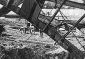 Close up showing the steel road bridge work and the work being undertaken behind the steam navvy