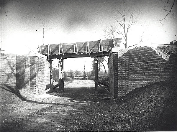 View of the building of a steel girder bridge being erected across a lane one mile south of Newton