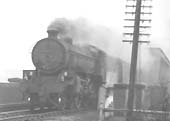 An unidentified ex-LNER Class B1 4-6-0 locomotive is seen working hard as it heads an up express