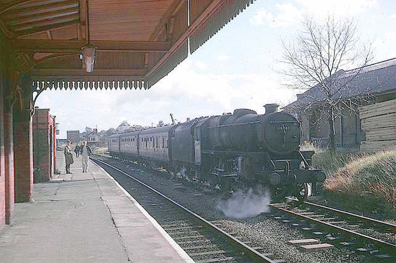 An unidentified ex-LMS 'Black Five' 4-6-0 stands on the passing loop line waiting for a London to Nottingham express to pass through Rugby