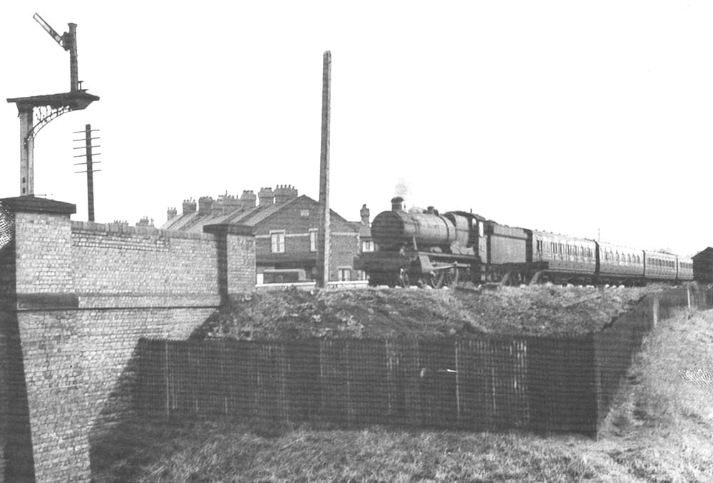 An unidentified ex-GWR Hall Class locomotive passes Rugby Cattle Sidings on a down express passenger service circa 1962