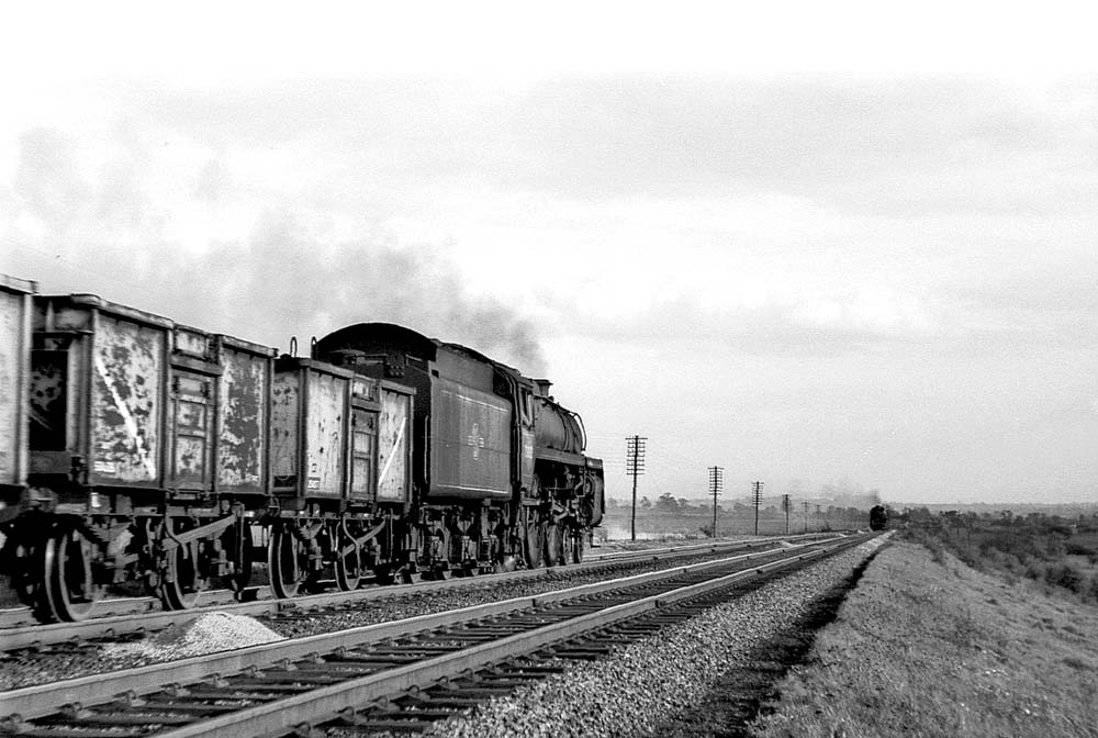 An unidentified British Railways Standard Class 5 4-6-0 locomotive rattles passed with an empty mineral train at Barby