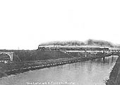 An unidentified GCR 4-4-0 is seen in full cry at the head of adown express crossing the Oxford Canal