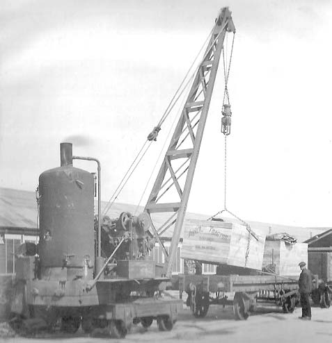 Two crates of �Austin Tractors� being loaded on to a single bolster railway wagon by a steam crane in the early 1920s