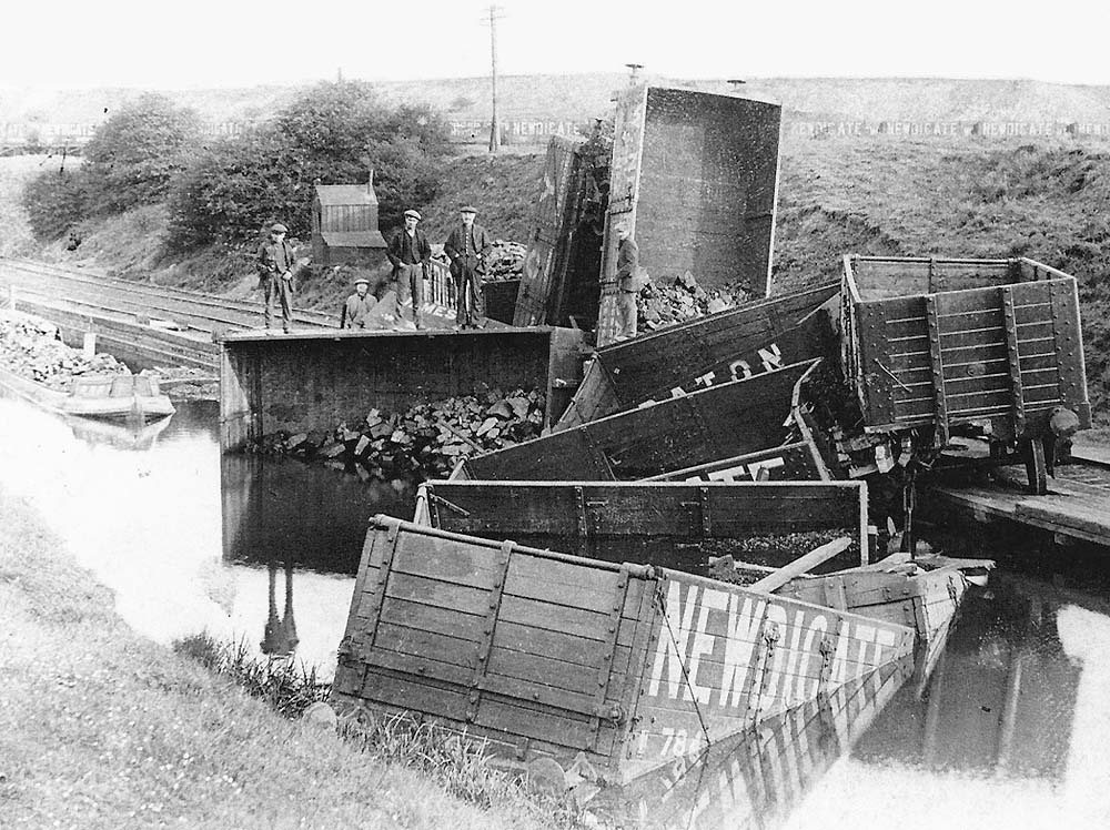 Photograph of a rake of derailed loose coupled Newdigate Colliery wagons lying in Coventry Canal on 21st May 1885