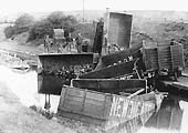 The first of a set of five photographs showing a rake of derailed loose coupled Newdigate Colliery wagons lying in Coventry Canal